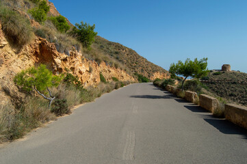 Carretera para poder hacer la ruta de los senderistas por la montaña de Benidorm hacia el gran mirador de toda la ciudad bajo un cielo azul soleado.