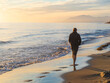 Hombre joven caminando por la orilla del mar
