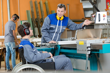 disabled worker in wheelchair in factory on the machine