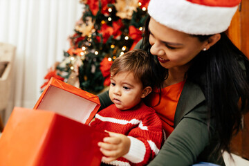 Wall Mural - Mother and her baby playing at home on Christmas holiday