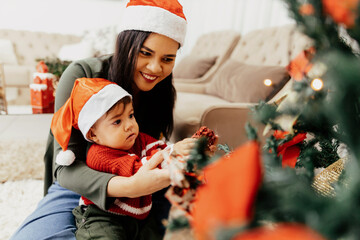 Wall Mural - Mother with baby son dacorating christmas tree