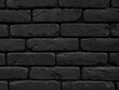 Black brick wall grunge texture background. Close up of brick tiles in a row.