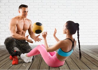 Wall Mural - Personal male trainer and young woman in gym.