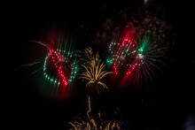 Green, Red And Yellow Fireworks Burst Into Various Shapes In The Dark Sky