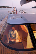 A Crew Navigates A Racing Yacht Home At Dusk Using High Tech Instruments.