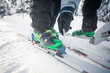 © Cavan Images - A backcountry skier uses a screw driver to set the DIN setting on his partners binding.