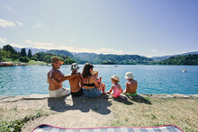 Family With Four Kids Sit In Pier Of View Beautiful Bled Lake, Slovenia. Parents Of Many Children.