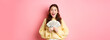 Wow I won. Excited brunette girl showing money and smiling, got her cash prize, holding dollar bills and looking happy, standing over pink background