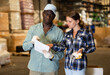 © JackF - Positive African American man and woman checking order list at hardware store warehouse