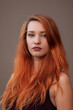 Close-up portrait of arrogant beautiful slim girl with long red hair