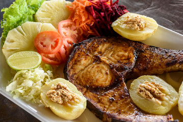 Wall Mural - Fried fish with pineapple, tomatoes, carrots, beets and potatoes. Brazilian food.