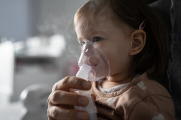 Wall Mural - one child toddler girl using steam inhaler nebulizer at home