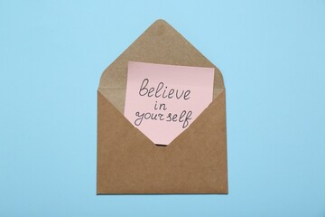 Wall Mural - Envelope with message Believe In Yourself on light blue background, top view. Motivational quote