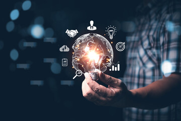 Fototapete - Male hand holding light bulb with globe falling around with business icons