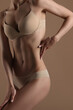 © Mirrorstudio - Thin young woman in underwear on beige background