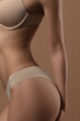 © Mirrorstudio - Thin young woman in underwear on beige background