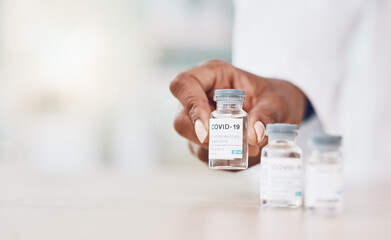 Poster - Hand, woman and doctor with covid vaccine bottle and working in her hospital office. Healthcare expert with a bottle, wellness or corona medicine in a medical research clinic for safety from covid 19