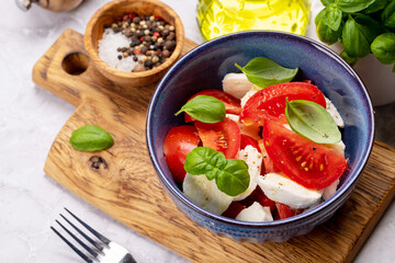 Canvas Print - Caprese salad with ripe tomatoes, mozzarella and garden basil