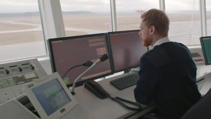  Surveillance Officer looking at Computer Screen in Central Office for air traffic control. Realtime
