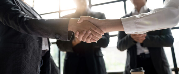 Wall Mural - Group business people handshake at meeting table in office together with confident. Young businessman and businesswoman workers express agreement of investment deal.