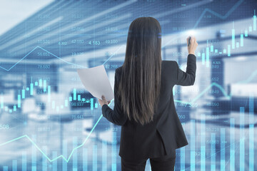 Canvas Print - Attractive young european woman using glowing business chart hologram and index on blurry office interior background. Finance, trade and invest concept. Double exposure.