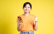 © STOCK88PHOTOGRAPHER - image of asian girl holding phone and isolated on yellow background