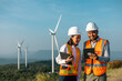 © Chanakon - Two Engineer man and woman working at windmill farm Generating electricity clean energy. Wind turbine farm generator by alternative green energy. Asian engineer checking control electric power