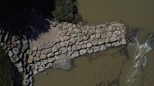 High-angle Video Panning Over A Rocky, Broken Dam In The Trinity River In Texas