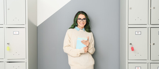 Canvas Print - Beautiful female student with books near lockers at the university