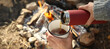 © Pixel-Shot - Woman drinking hot tea bonfire in autumn forest