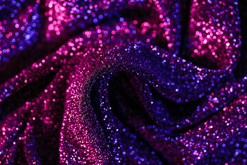 Shiny purple fabric in neon light as background