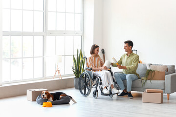 Sticker - Young man with his wife in wheelchair and dog packing things in room on moving day