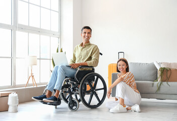 Canvas Print - Young woman and her husband in wheelchair in room on moving day