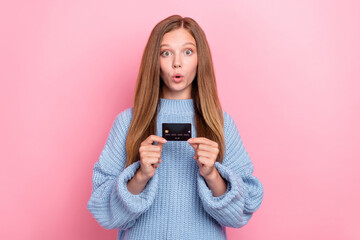 Poster - Photo of youngster teen girl wear knitted blue sweater pouted lips shock hold new debit card high profit percent isolated on pink color background