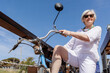 anziana signore con le propria bicletta vintage isolata su sfondo blu del cielo