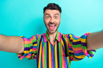 Wall Mural - Portrait of positive astonished guy with brunet haircut wear colorful shirt shouting impressed sale isolated on teal color background