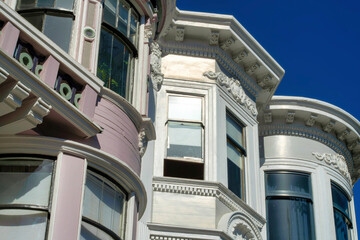 Row of modern building facades with gray white and purple and dark blue sky background in midday sun in urban area downtown