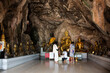 Carving stone and sculpture buddha image statue on cave wall for thai people travel visit respect praying blessing mystical at limestone mountain rock park on November 3,2022 in Ratchaburi, Thailand