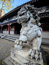 Vertical Shot Of A Chinese Guardian Lion Statue In Front Of A Temple