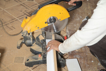 Wall Mural - Worker cutting part of furniture with cutting machine.