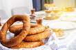 Turkish bagel called simit, close up and selective focus of Turkish bagel called simit. Morning light on traditional breakfast table. Copy space. Tea in glass, su borek, cheese, bread, jam.