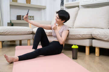 Wall Mural - An Asian young woman is workout on fitness mat , exercise at home , healthy lifestyle concept