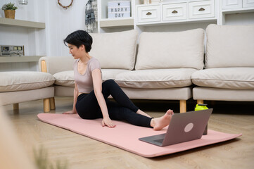 Wall Mural - An Asian young woman is workout on fitness mat , exercise at home , healthy lifestyle concept