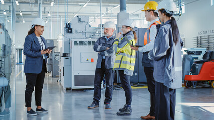 Factory Meeting: Black Female Chief Engineer Talking to Colleagues Before Work Day in Heavy Industry Manufacturing Facility. Diverse Group of Employees Listening to Manager.