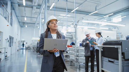 Aufkleber - Portrait of an African Female Engineer in Hard Hat Walking and Using Laptop Computer at Electronic Manufacturing Factory. Technician Working on Daily Tasks and Research and Development Data.