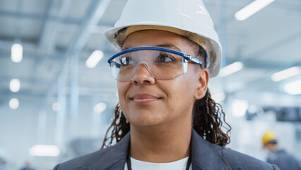 Fototapete - Close Up Portrait of a Happy and Smiling Middle Aged African Female Engineer in White Hard Hat Standing at Electronics Manufacturing Factory. Black Heavy Industry Specialist Supervising Work.