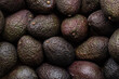 Ripe dark avocados as background