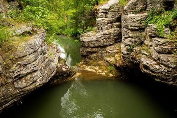 Poster - Beautiful shot of a lake surrounded by cliffs in a forest