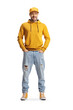 Full length portrait of a young man in a yellow hoodie and jeans posing with hands in pockets