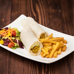 Wall Mural - Arabic kebab sandwich shawarma roll wrap withsalad and fries served in dish isolated on table top view of fastfood